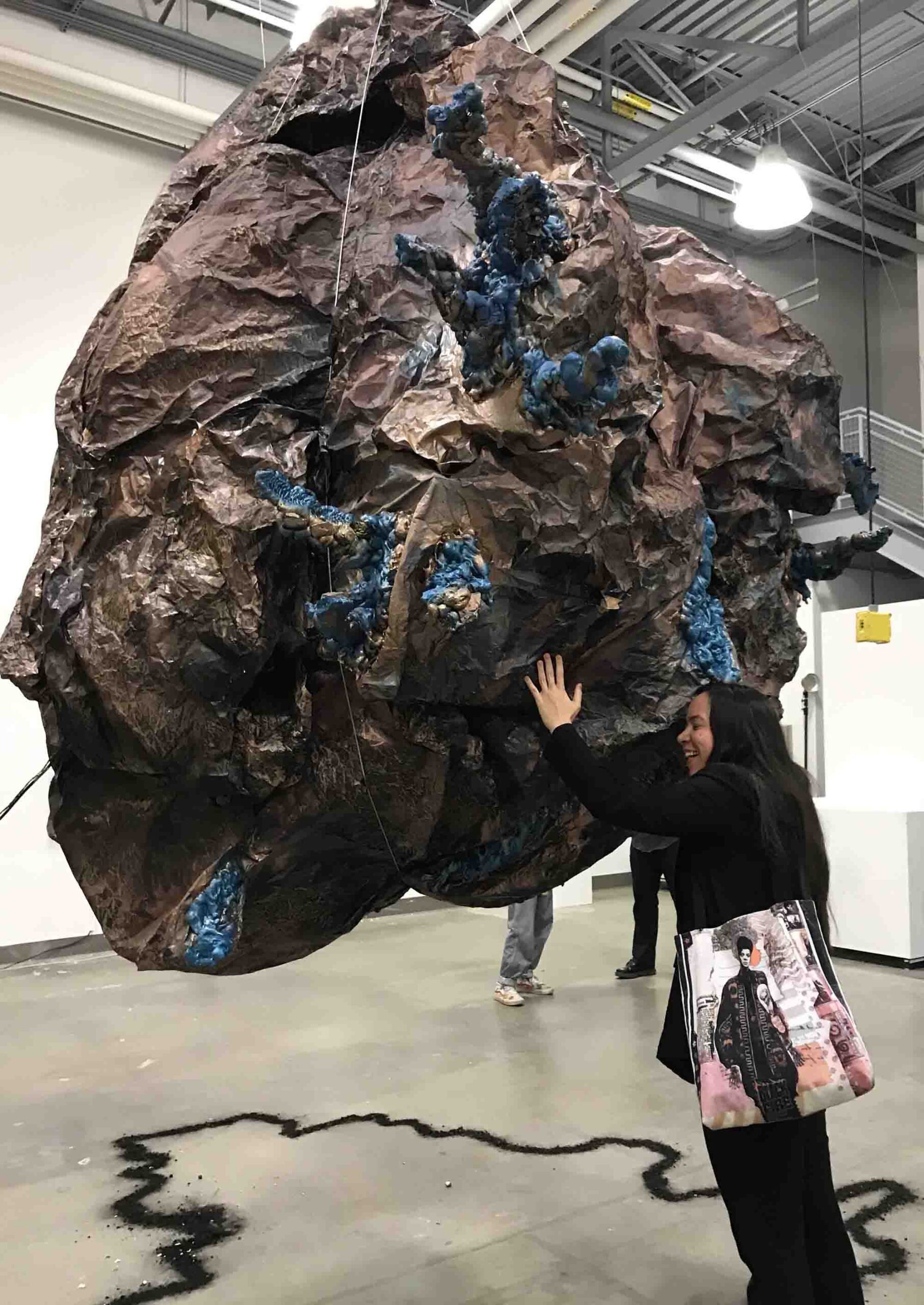 spectator hugging breathing boulder sculpture